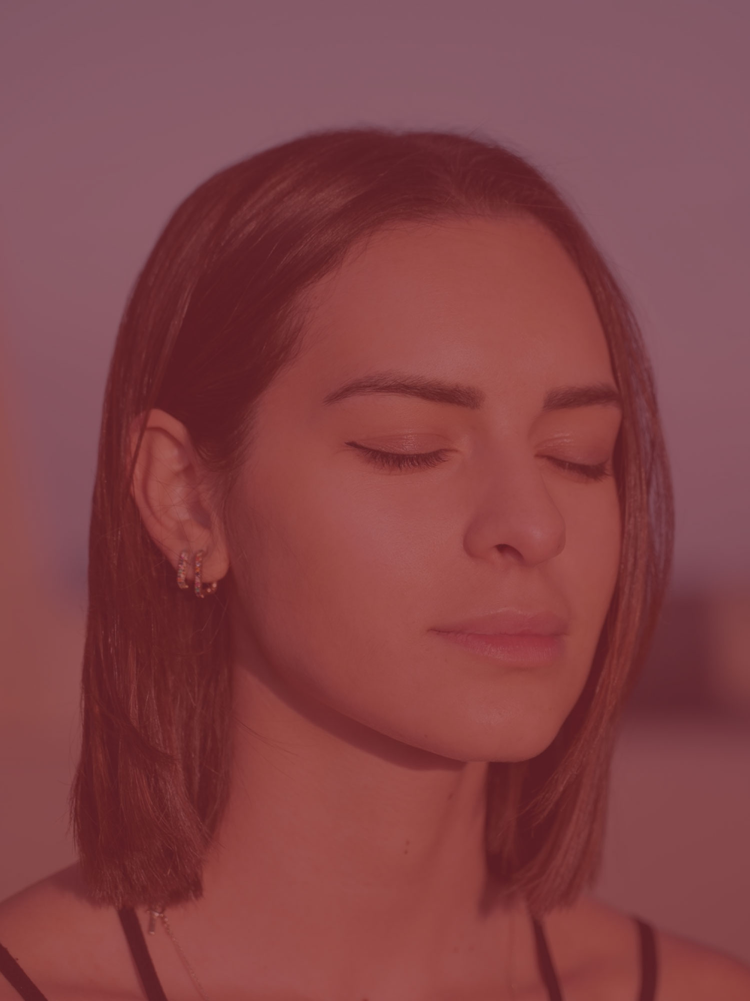 Mulher de olhos fechados, em um momento de pausa e atenção a si mesma